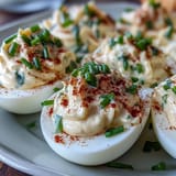 Million Dollar Deviled Eggs with creamy filling and paprika garnish arranged on a platter.