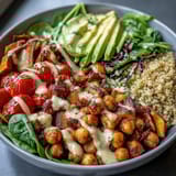 Vibrant fresh vegetables and golden roasted sweet potatoes create a colorful, nourishing Buddha Bowl served with a drizzle of garlic tahini dressing.