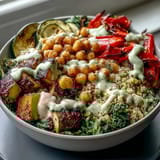 Colorful roasted zucchini and sweet peppers top chickpeas and fluffy bulgur, drizzled with lemony tahini dressing for a vibrant Mediterranean Buddha Bowl Meal Prep.