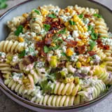 Bright Mexican street corn pasta salad featuring charred corn, tangy lime dressing, and crumbled Cotija cheese.  