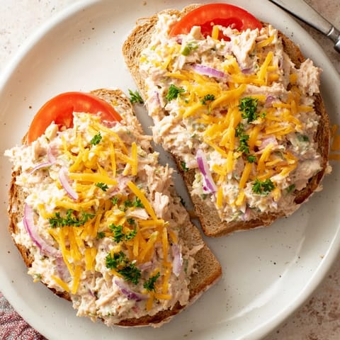 Warm and toasty bread holds a creamy tuna filling topped with melted cheese in this comforting open-faced Tuna Melt.