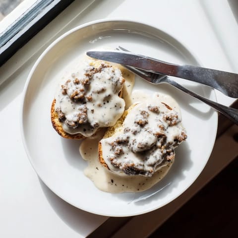 Golden-brown, flaky biscuits topped with creamy, peppery sausage gravy for a classic Southern breakfast.
