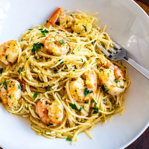 Golden shrimp sautéed in garlic butter mingle with tender angel hair pasta, soaked in a vibrant lemon sauce and sprinkled with fresh parsley for extra flavor.