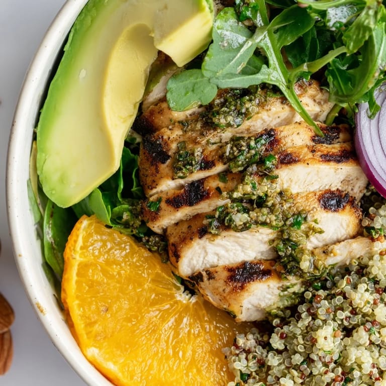 Creamy avocado slices and crisp red onion mingle with toasted almonds and zesty orange segments, drizzled with citrus vinaigrette over this refreshing Citrus Herb Chicken Salad Bowl.