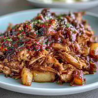 Honey Peach BBQ Pulled Pork slow-cooked in a crockpot, tender meat in sweet and smoky sauce with juicy peach slices.  